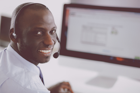 African american businessman on headset working on his laptopの写真素材
