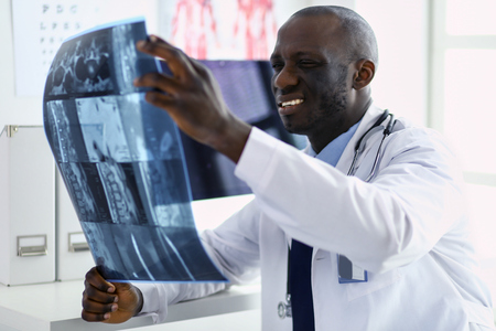 Portrait young african medical doctor holding patients x-rayの写真素材