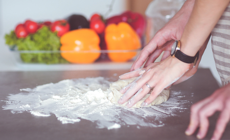 Young couple prepared cake standing in the kitchenの写真素材