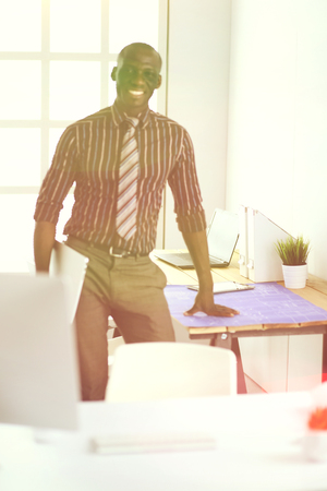 African american architect working with computer and blueprints in officeの写真素材