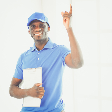 Portrait of an handsome happy deliverer with folderの写真素材
