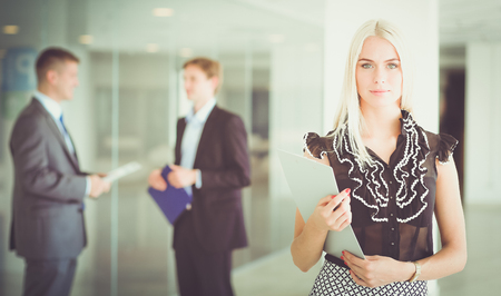 Portrait of young businesswoman in office with colleagues in the background .の写真素材