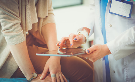 Doctor and patient discussing something while sitting at the table . Medicine and health care concept. Doctor and patient.の写真素材
