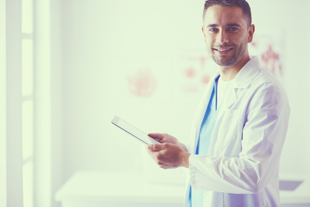Young and confident male doctor portrait standing in medical office.の写真素材