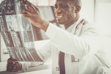 Portrait young african medical doctor holding patients x-rayの写真素材
