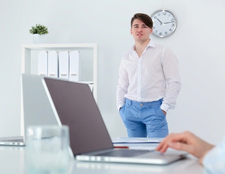 Young businessman working in office, sitting at deskの写真素材