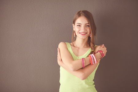 Portrait of a young smiling woman on a gray wall backgroundの写真素材