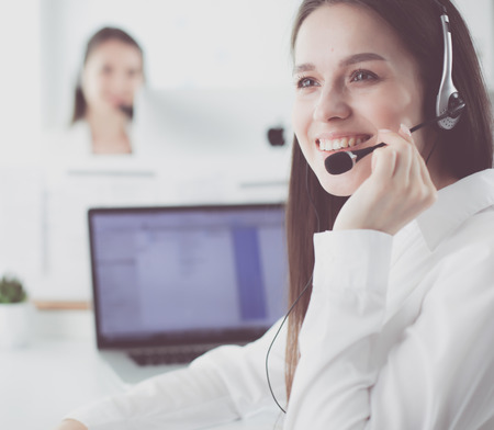 Smiling businesswoman or helpline operator with headset and computer at officeの写真素材