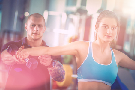 Beautiful woman at the gym exercising with her trainer. Beautiful woman. Gymの写真素材