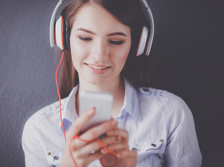 Smiling girl with headphones sitting on the floorの写真素材