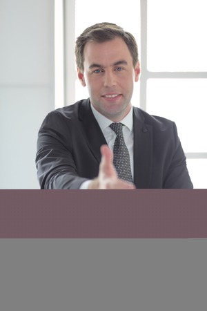 Portrait of businessman giving hand for handshake.の写真素材