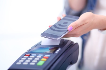 Customer is paying with smartphone in shop using NFC technology. NFC technology. Customer is payingの写真素材