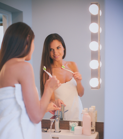 Attractive young woman applying cream on her Faceの写真素材