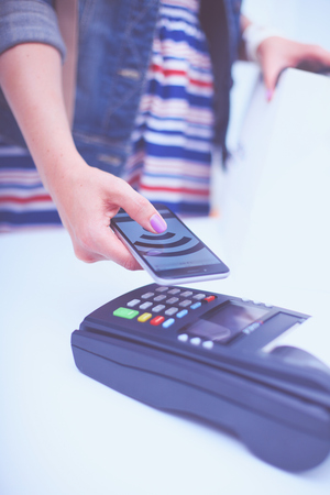 Customer is paying with smartphone in shop using NFC technology. NFC technology. Customer is payingの写真素材