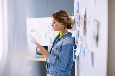 Fashion designer woman working on her designs with ipad in the studioの写真素材