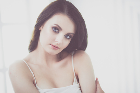 Beautiful brunette lying on bed at home.の写真素材