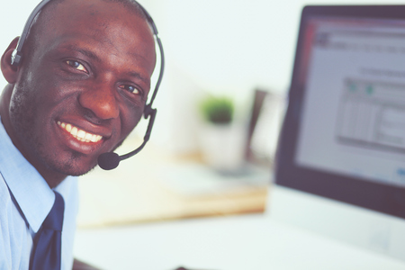 African american businessman on headset working on his laptopの写真素材