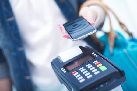 Customer is paying with smartphone in shop using NFC technology. NFC technology. Customer is paying.の写真素材