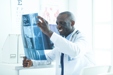 Portrait young african medical doctor holding patients x-rayの写真素材