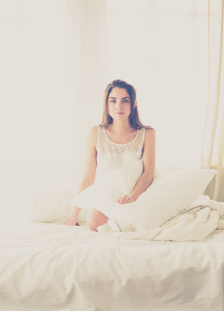 Pretty woman lying down on her bed at homeの写真素材