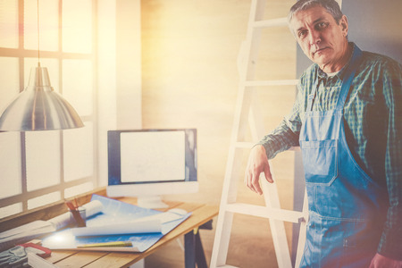 Architect working on drawing table in officeの写真素材