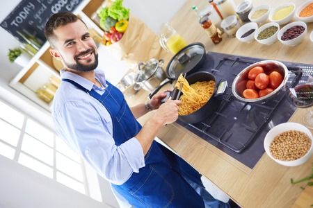 Man preparing delicious and healthy food in the home kitchenの写真素材