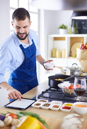 Man preparing delicious and healthy food in the home kitchenの写真素材