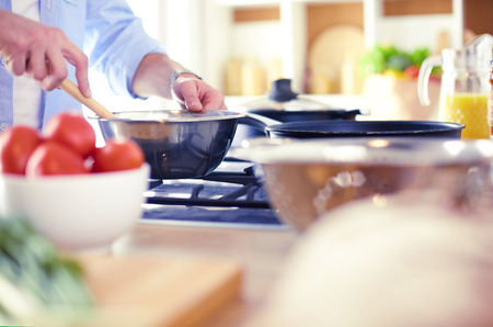 Man preparing delicious and healthy food in the home kitchenの写真素材