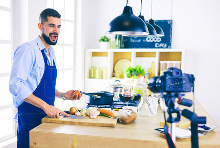 Man holding paper bag full of groceries on the kitchen background. Shopping and healthy food conceptの写真素材