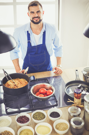 Man preparing delicious and healthy food in the home kitchenの写真素材