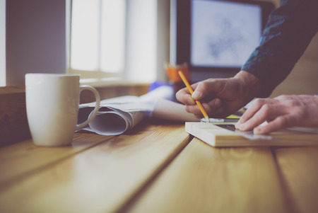 Architect working on drawing table in officeの写真素材