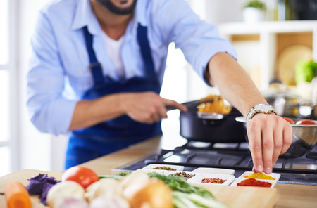 Man preparing delicious and healthy food in the home kitchenの写真素材