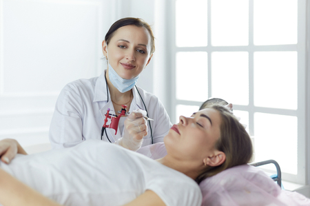 A young girl having red lips permanent makeup, micropigmentationの写真素材