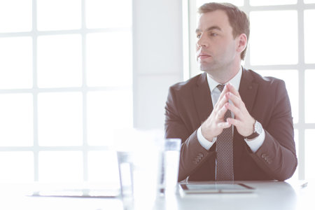 Portrait of young man sitting at his desk in the office.