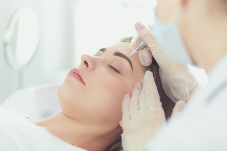 A young girl having red lips permanent makeup, micropigmentationの写真素材