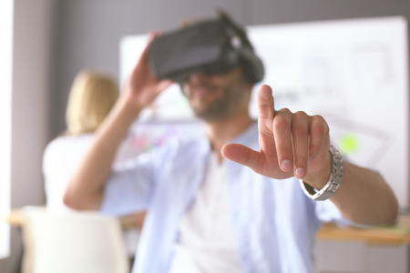 Young male software programmer testing a new app with 3d virtual reality glasses in office.の写真素材