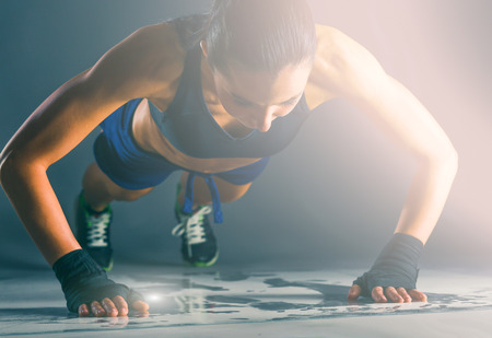 Young woman doing push ups on a mat.の写真素材