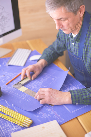 Architect working on drawing table in officeの写真素材