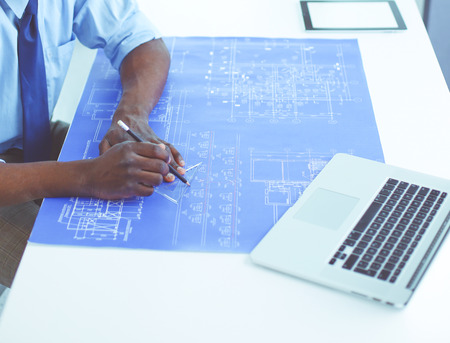 African american architect working with computer and blueprints in officeの写真素材