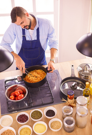 Man preparing delicious and healthy food in the home kitchenの写真素材