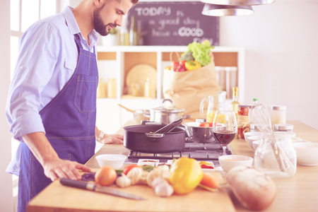 Man preparing delicious and healthy food in the home kitchenの写真素材