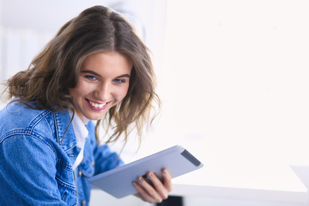 Portrait of beautiful business woman working at her desk with headset and laptopの写真素材