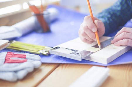 Architect working on drawing table in officeの写真素材