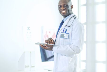 Male black doctor worker with tablet computer standing in hospitalの写真素材