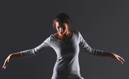 Attractive young woman full length portrait isolated on grey backgroundの写真素材