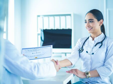 Doctor shakes hands with a patient isolated on white backgroundの写真素材