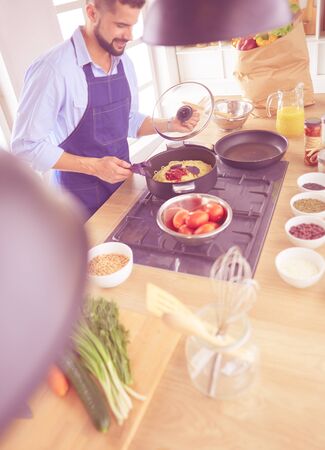 Man preparing delicious and healthy food in the home kitchenの写真素材