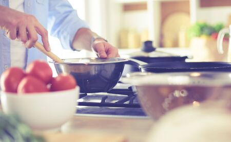 Man preparing delicious and healthy food in the home kitchen.の写真素材