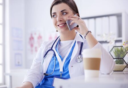 Female doctor talking on phone in diagnostic centerの写真素材