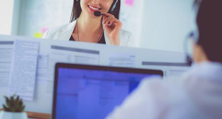 Smiling businesswoman or helpline operator with headset and computer at officeの写真素材